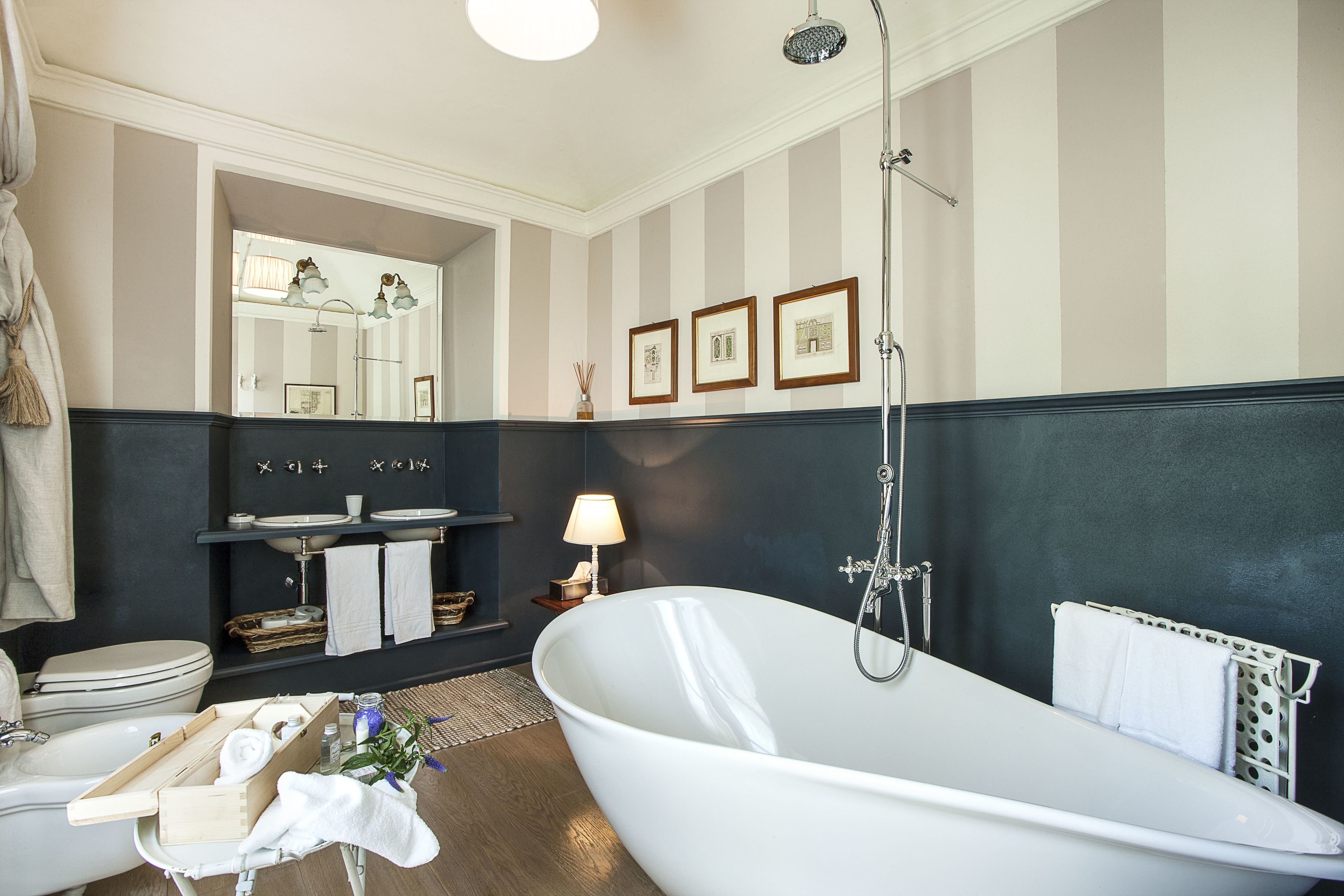 A modern bathroom with a freestanding bathtub, a vanity with a mirror, and a toilet.