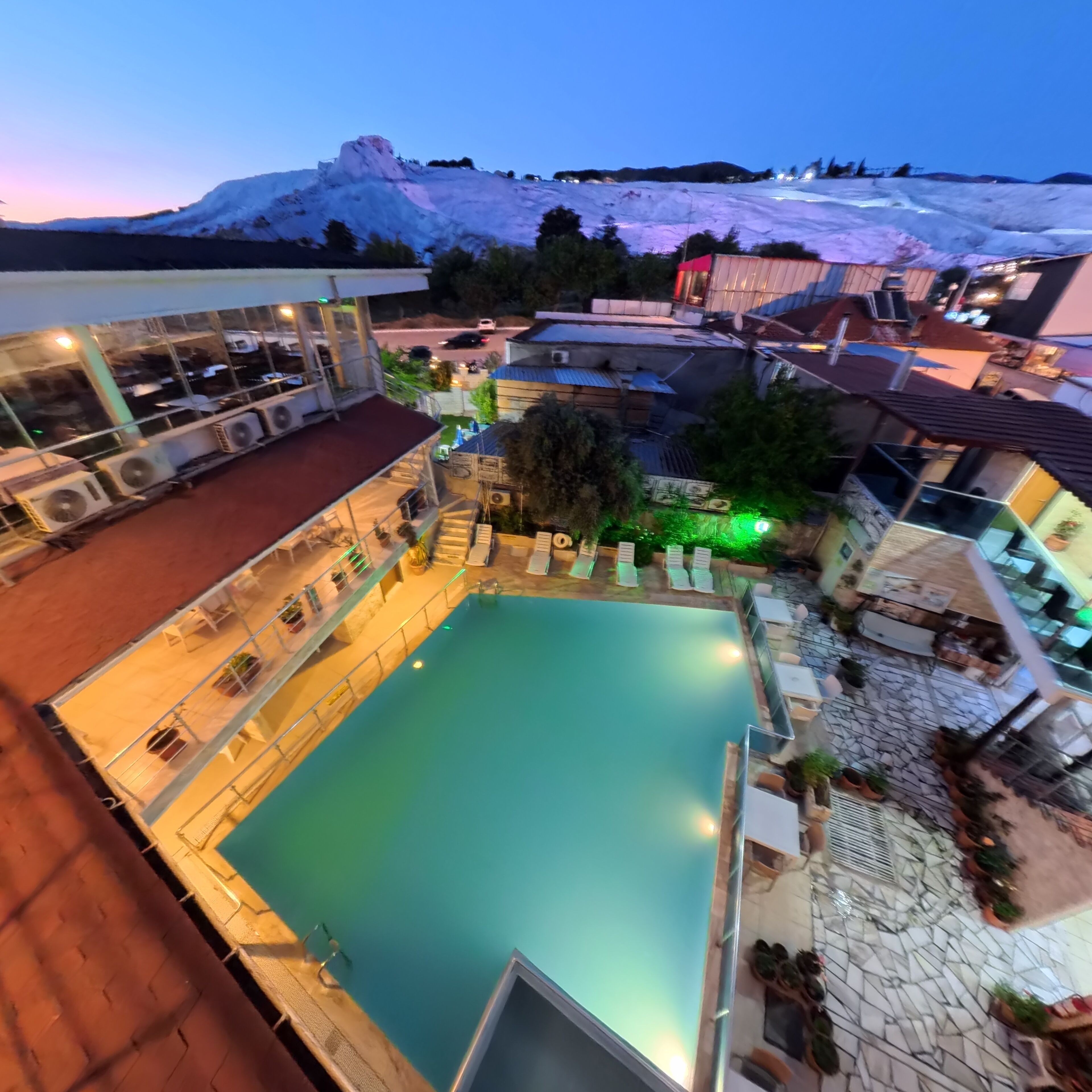 A rooftop pool area with a view of a snowy mountain.