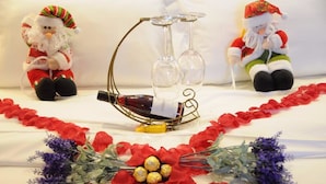Een tafel met een fles wijn, twee glazen en een decoratieve standaard.