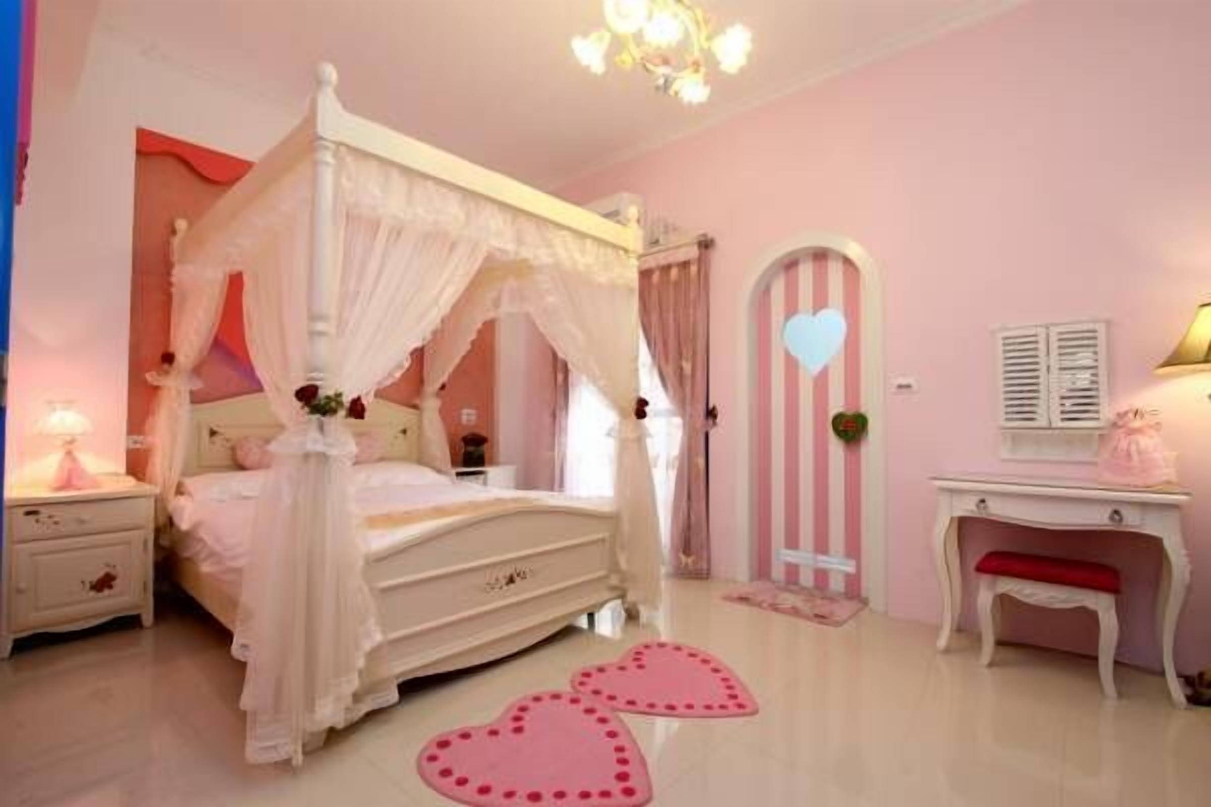 A bedroom with a four-poster bed, a vanity with a mirror, and a bench.