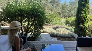 A person sitting on a patio with a view of a garden. - Nature ET Design (Bonifacio)
