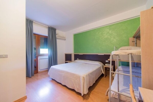 A room with a bunk bed, a single bed, and a green wall. - Hotel del Camerlengo (Fara San Martino)