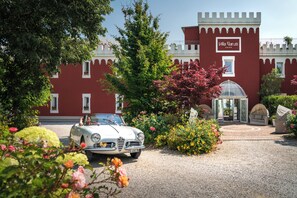 A vintage car parked in front of a castle-like building with a sign reading 'Villa Garutti.' - Villa Garuti (Padenghe sul Garda)