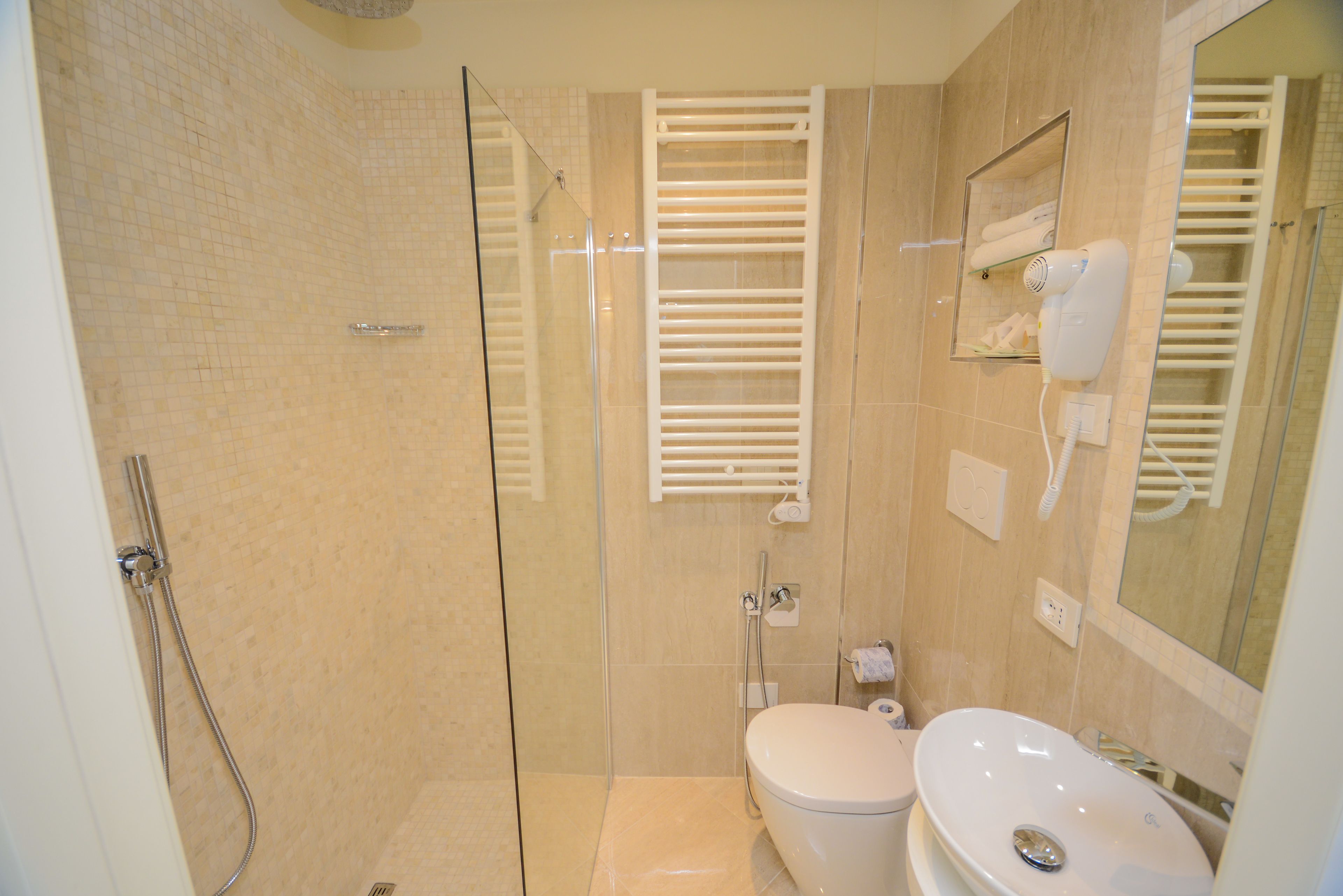 A modern bathroom with a glass-enclosed shower, a toilet, and a sink.
