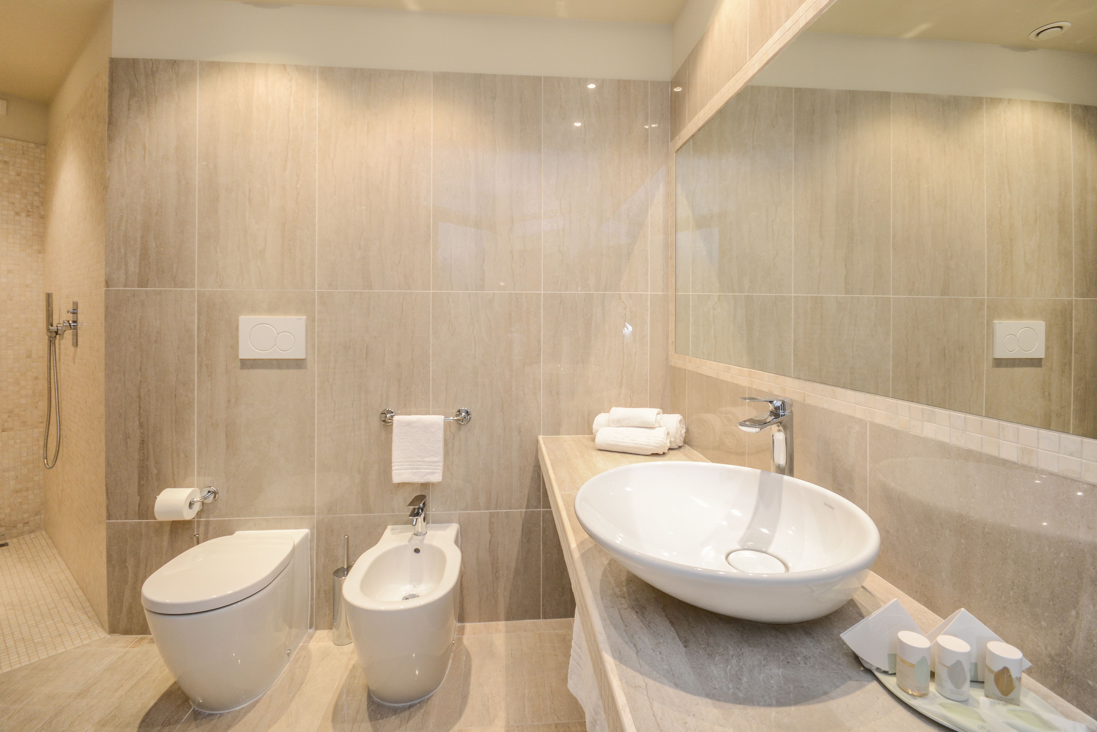 A modern bathroom with a bidet, toilet, and large sink.