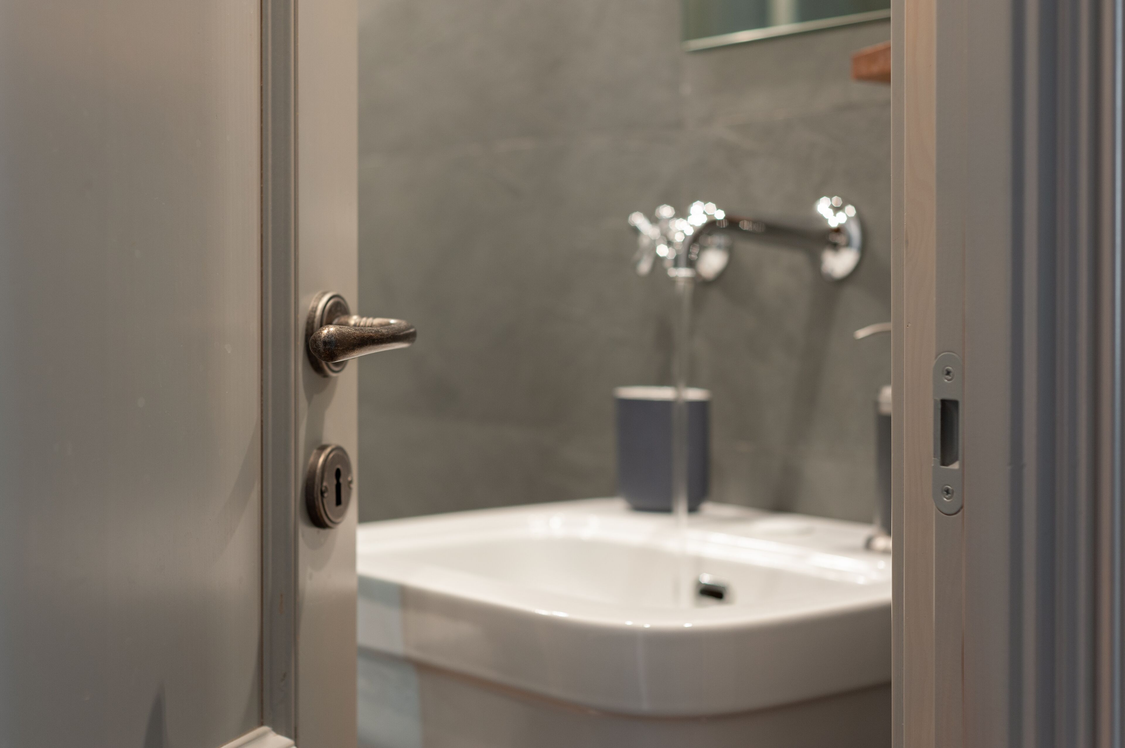 Un baño con lavamanos, grifo y taza.