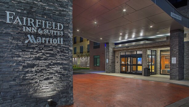 A Marriott Fairfield Inn & Suites entrance with a stone facade and a wet ground surface. - Fairfield Inn & Suites by Marriott Nashville Hendersonville (Hendersonville)
