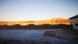 A fenced outdoor area with a building on the right. - Hotel Fljotshlid (Rangárþing eystra)