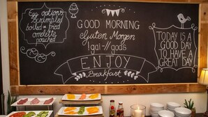 A breakfast buffet with various food options and a chalkboard with positive messages. - Desert Sands Boutique B&B - Self-Catering (Swakopmund)