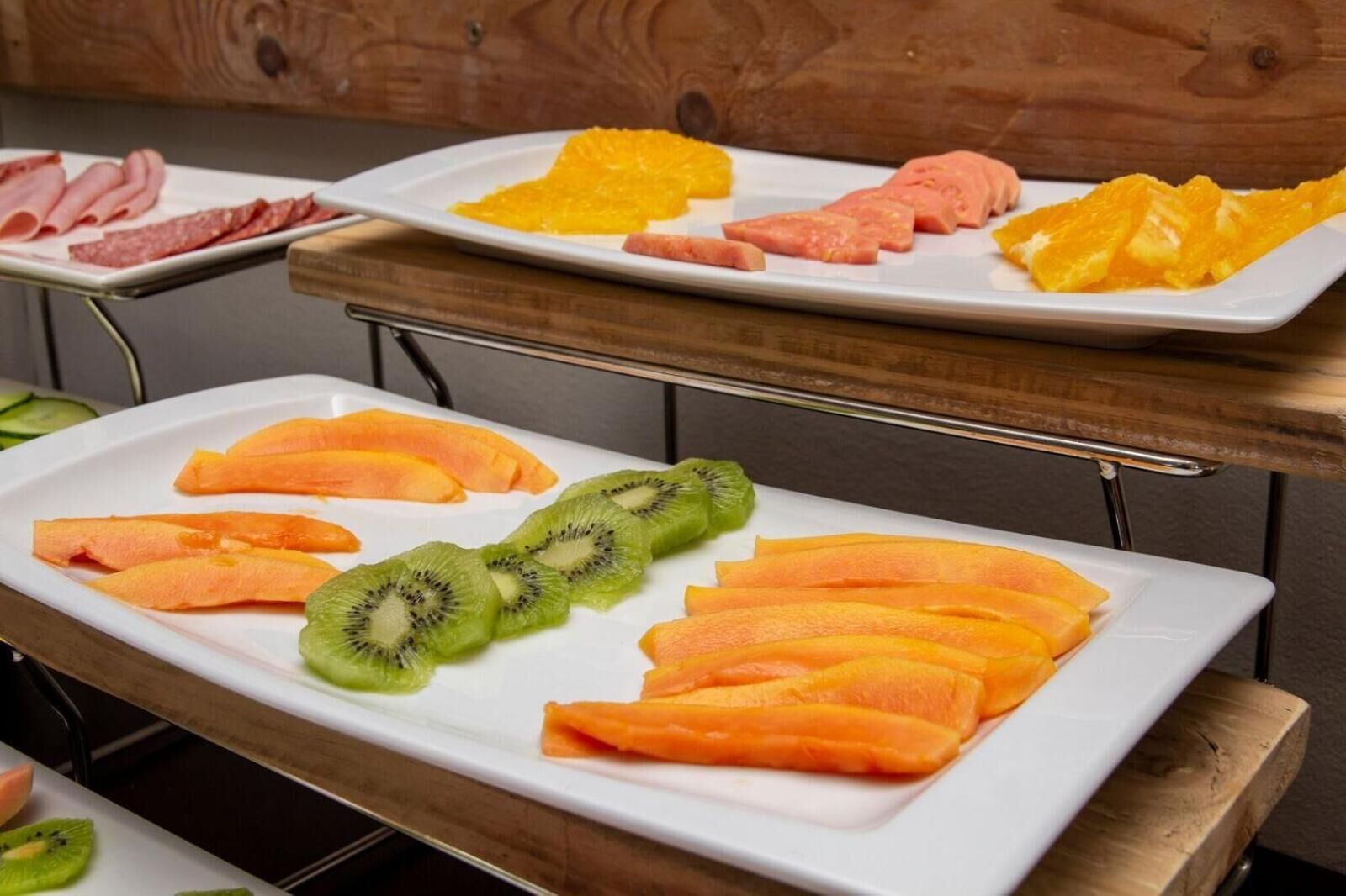 Un buffet proposant une variété de fruits et de viandes.