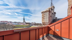 A balcony with a view of a historic tower and a church spire in the background. - Lighthouse Apartments Tallinn (Tallinn)