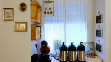 Una encimera de cocina con una cafetera, dos hervidores eléctricos y un tarro de vidrio con huevos.