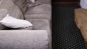 A hotel room with a bed, a TV on a stand, a wardrobe, and a patterned carpet. - Fourways Guest House (Thirsk)