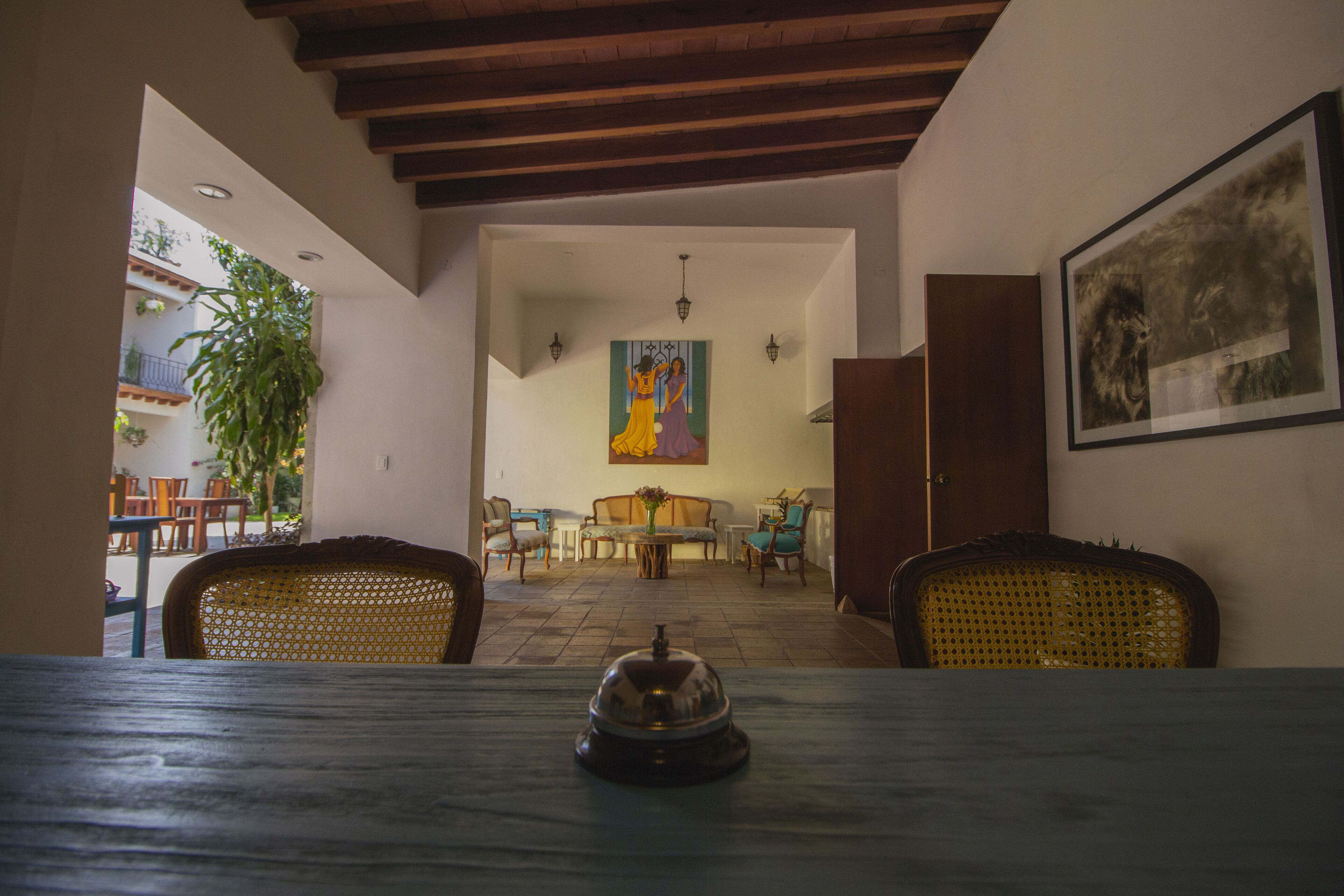 Uma área de refeições com uma mesa posta para dois, teto de madeira e um quadro na parede.