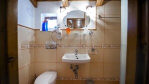 Ein kleines Badezimmer mit Toilette, Waschbecken und einem Spiegel darüber.