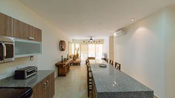 A modern kitchen with granite countertops, wooden cabinets, a built-in oven, and a microwave.