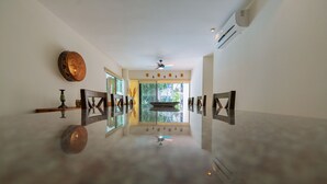 A spacious, well-lit hallway with a ceiling fan, a large mirror, and a view of the outdoors through a glass door. - Private pool Access 2BR condo in the best location in Tulum (Tulum)
