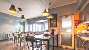 A modern kitchen with a large island, bar stools, pendant lighting, and a chalkboard menu. - Atlantic Home Azores (Ponta Delgada)