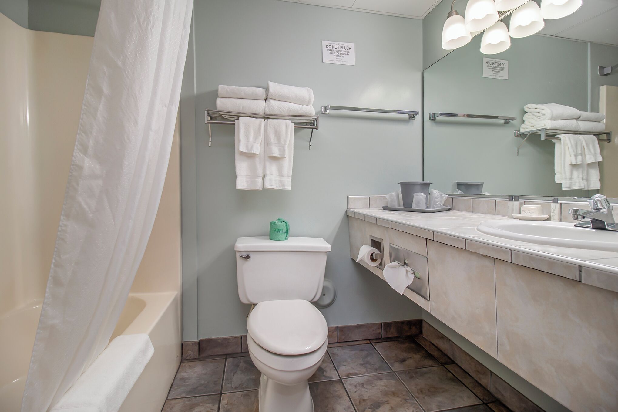 A bathroom with a toilet, sink, and towel rack.