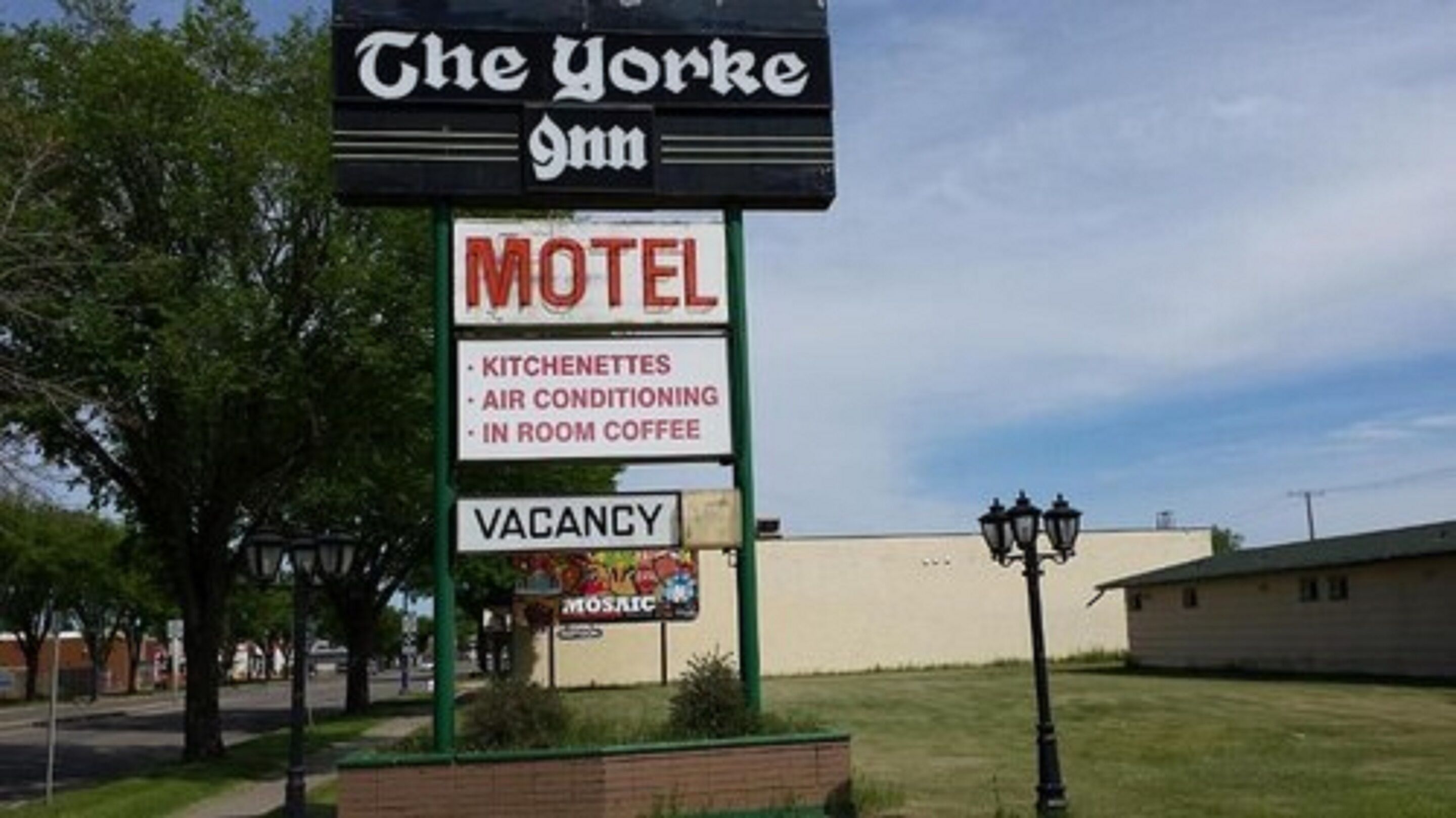A motel sign with amenities including kitchens, air conditioning, and in-room coffee.