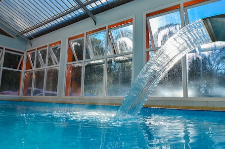 Una piscina techada, sillones reclinables de piscina. Hotel Renascença