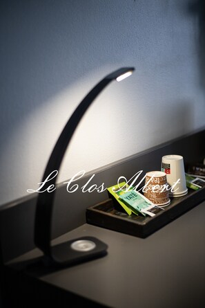 Un bureau avec une lampe de bureau, une tasse et un plateau contenant un sachet de thé Yate et une tasse blanche.