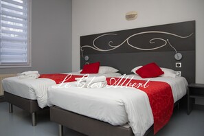 A double bed with white and red bedding, a modern headboard, and a bedside table with a lamp. - Le Clos Albert (Loudun)