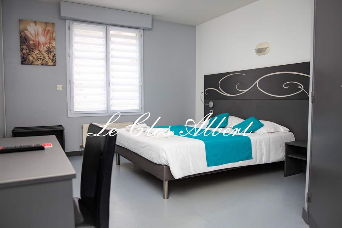 Un dormitorio moderno con cama, escritorio y silla.
