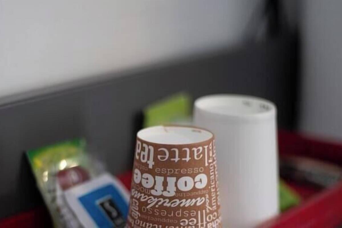 Una cafetera, un rollo de toallas de papel y una bandeja roja.