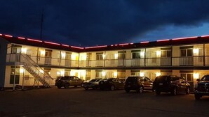 A motel with multiple floors, a covered parking area, and a staircase leading to the upper levels. - Elk Point Motel & RV Park (Elk Point)
