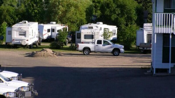 A parking area with RVs and a white pickup truck. - Elk Point Motel & RV Park (Elk Point)