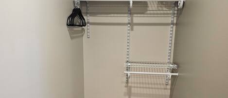 A compact storage unit with shelves and a trash bin.