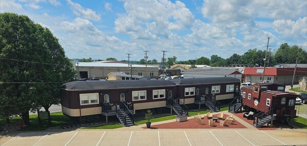 A train-themed lodging with multiple cabins, outdoor seating, and a parking area. - Sugarcreek Village Inn (Sugarcreek)