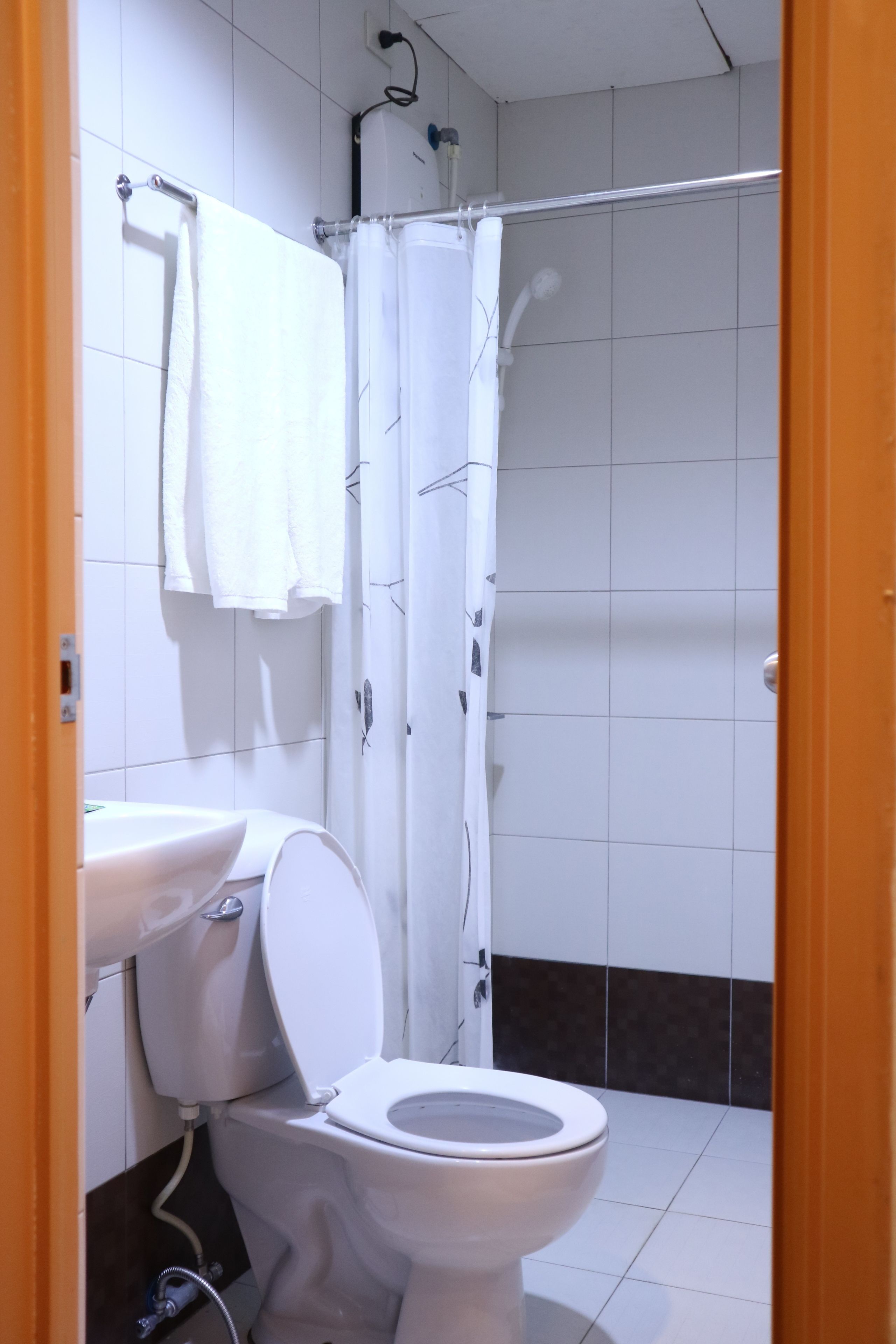 A bathroom with a toilet, sink, and shower.