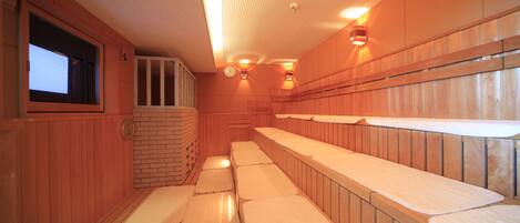 Una sauna con bancos de madera y suelo de baldosas.