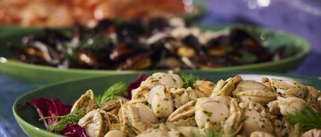 A close-up of a seafood dish with mussels and herbs.