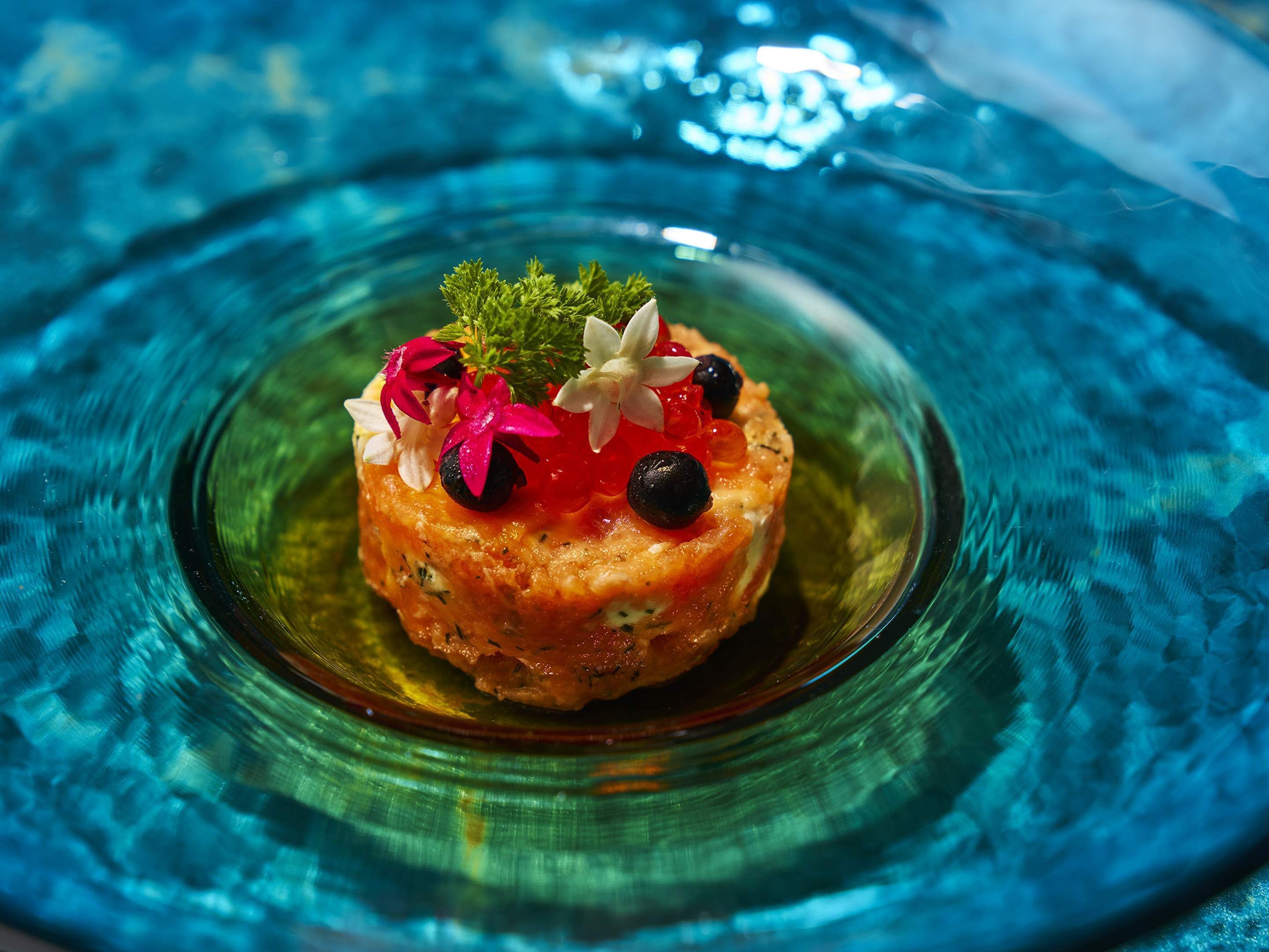 Een gerecht met garnering op een glazen bord.