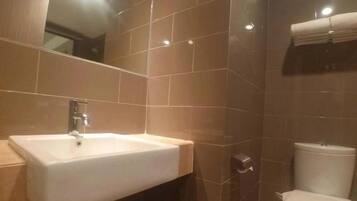Un baño moderno con un lavabo blanco, un espejo y un inodoro.