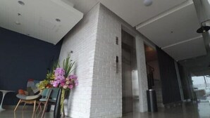 Un intérieur moderne avec un mur d’accent en briques blanches, un escalier et un vase de fleurs.