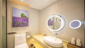 A modern bathroom with a large oval sink, a round mirror with a light, and a painting of lavender fields on the wall. - LAVADE HOTEL GZ KECUN METRO STATION BRANCH (Guangzhou)