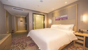 A hotel room with a large bed, a bedside table, a nightstand, a wall-mounted TV, and a door leading to another room. - LAVADE HOTEL GZ KECUN METRO STATION BRANCH (Guangzhou)