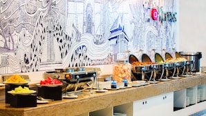 Un buffet proposant une variété de plats et d’ustensiles de service.