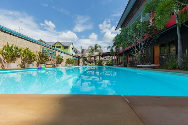 Alberca al aire libre y camastros