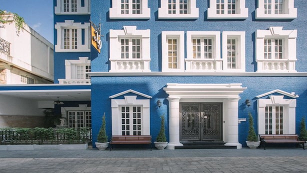 Un edificio con facciata blu, decorazioni bianche e numerose finestre.