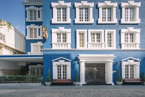 A building with a blue facade, white trim, and multiple windows. - X9Hostel (Bangkok)