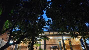 Um edifício com fachada de tijolos, uma varanda com grade e uma mesa e cadeiras na varanda.
