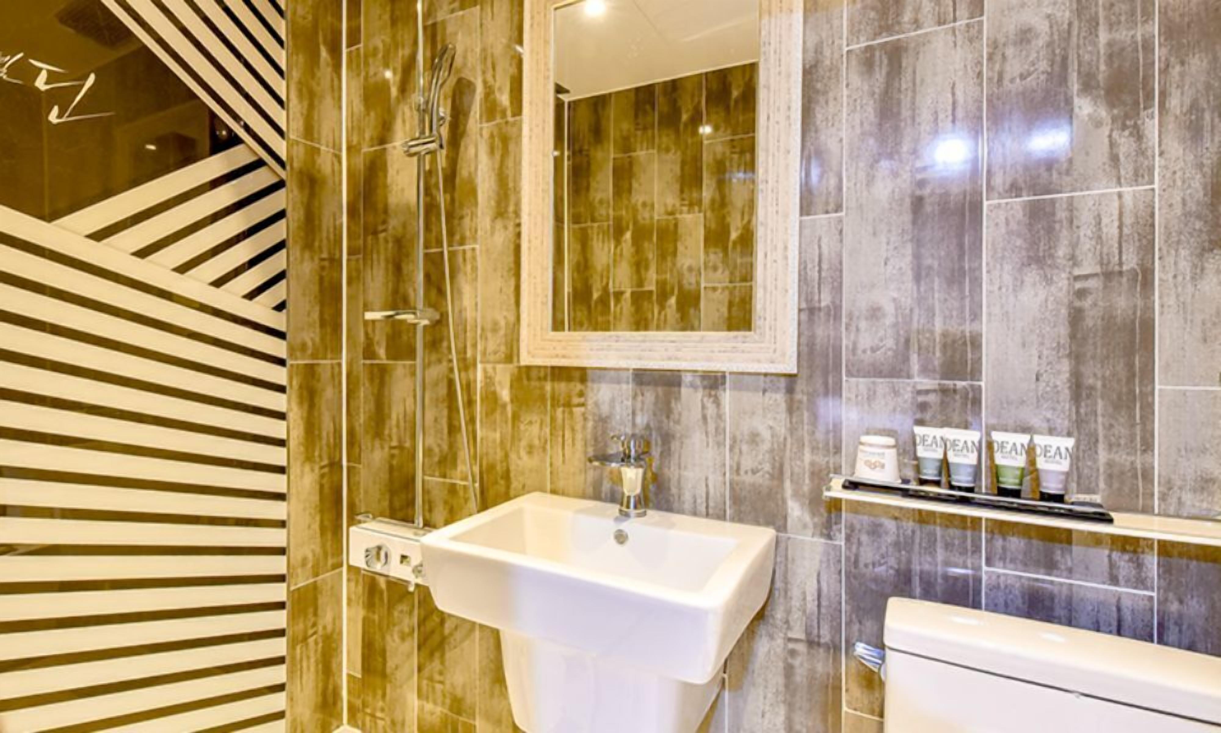 Une salle de bain moderne avec un grand lavabo, un miroir et des toilettes.