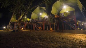A series of dome-shaped tents with external staircases and railings, illuminated by artificial lighting. - 360 Rainforest (Deniyaya)