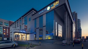 A modern hotel building with a prominent sign reading "KONAK YI AYKUN HOTEL" and a visible entrance. - AyKun Hotel (Astana)