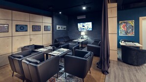 A modern conference room with a large table, several chairs, a television, and decorative wall art. - AyKun Hotel (Astana)